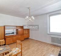 A room in a 2-room apartment with older furniture and a floor with a wood decor.