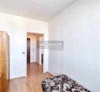 A room in a 2-room apartment with a bed, a wardrobe, and a floor with a wooden decor.