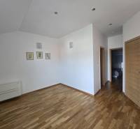 Interior of a holiday apartment with wood-patterned flooring and white walls.