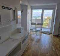 Recreational apartment with wood-patterned flooring, balcony with sea view.