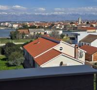 The view from the holiday apartment in Nin captures the rooftops of houses and the nearby sea.