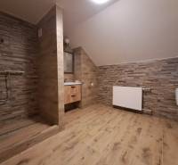 Bathroom with toilet and shower, wooden decor flooring, 3-room apartment.
