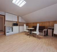 A cozy apartment with a kitchen, wooden decor flooring, and a dining table in a 3-room flat.
