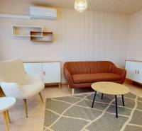 Living room with a sofa, armchair, and sideboard in a 3-room apartment, with a wooden decor floor.
