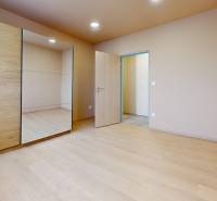 Bedroom in a 3-room apartment with a wooden decor floor and a built-in wardrobe.