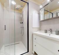 Bathroom in a 3-room apartment with a sink, mirror, and shower.
