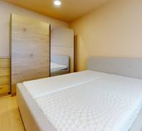 Bedroom with a bed, dresser, and wardrobe; floor with wood decor in a 3-room apartment.