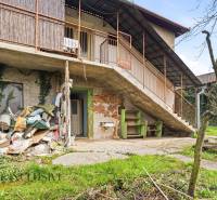 A family house in Malá nad Hronom with an external staircase and a garden, with stored items on the ground floor.