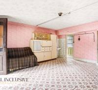 Living room in a family house with a vintage cabinet, sofa, and patterned floor.