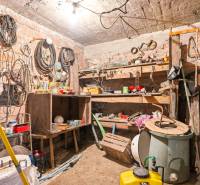 Workshop in a family house with tools and materials, brick walls.