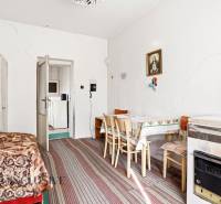 Dining room in a family house with white walls, a painting, a table, chairs, and a carpet.