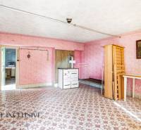 A room in a family house with a traditional stove and colorful tiled floor.