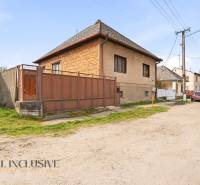 A family house in the village of Malá nad Hronom with a gate and a stone fence.