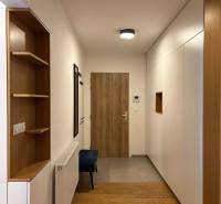 A hall in a 3-room apartment with a wooden decor floor and built-in wardrobes.