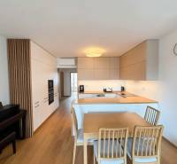 A kitchen with a dining table; floor with wooden decor; 3-room apartment.
