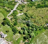 Aerial view of residential plots in Tornaľa, surrounded by greenery and buildings.