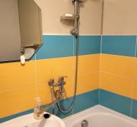 Bathroom in a 2-room apartment with colorful tiles and a mirror above the sink.