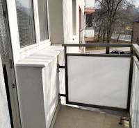 The balcony of a 2-room apartment on Hviezdoslavova Street in Čadca with a view of the street and trees.