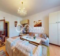 Living room with wood-patterned flooring, comfortable furniture, and a chandelier in a family house.