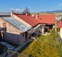 A family house in Spišské Vlachy with a yard, a roof, and a view of the mountains.