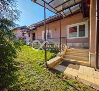 A family house in Spišské Vlachy with a lawn and a covered terrace, surrounded by greenery.