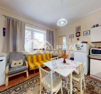 Family house kitchen with carpet, dining table, and kitchen unit.