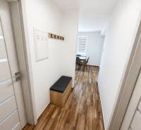 Hallway with a coat rack and a bench, 2-room apartment with a wooden decor floor.