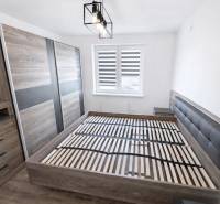 A bright bedroom in a two-room apartment with a wooden decor floor and stylish furniture.