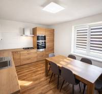 A kitchen in a 2-room apartment with a wooden decor floor and a dining table.