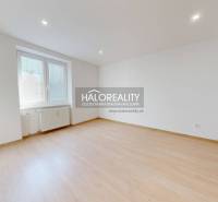 A spacious room with light walls and a wooden decor floor.