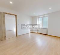 A room with a wooden decor floor in a 2-room apartment, a bright room with a window.
