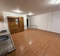 Studio apartment with a kitchenette and a wooden decor floor.