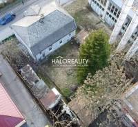 A family house in Rimavská Sobota with an asphalt road, an older roof, and a spacious yard.