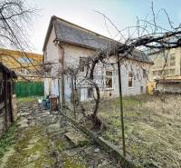 A family house in Rimavská Sobota with an unkempt garden and visible bare trees.