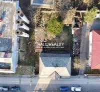 Aerial view of a family house in Rimavská Sobota next to an industrial building with four chimneys.
