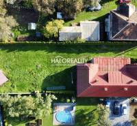 A family house in Hrachovo with a red roof and a green garden, pools, and a gazebo.