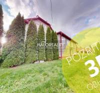 A family house in Hrachovo surrounded by conifers and lawn, sunny weather.
