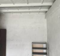 Shelves and a cabinet in the garage, simple interior with a gray floor.