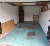 Garages on Kozmonautov Street in Martin with blue flooring and a shelf on the wall.