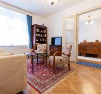 Living room in a 3-room apartment with a decorative carpet and wooden decor flooring.