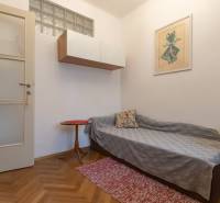 A room in a 3-room apartment with a wooden decor floor and minimalist furniture.