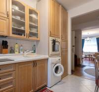 The kitchen of a 3-room apartment with wooden decor furniture and appliances.