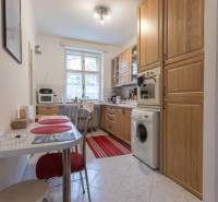 A kitchen in a 3-room apartment with a dining area, cabinets, and appliances.