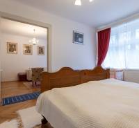 A bedroom with a wooden bed in a 3-room apartment and a floor with a wooden decor.