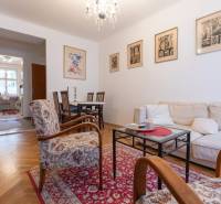 Living room with a sofa, armchairs, and a wooden decor floor in a three-room apartment.