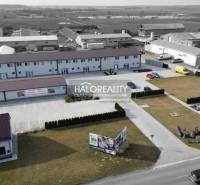 Industrial zone with commercial spaces, parking lot, and buildings, ideal for business purposes.