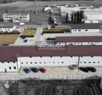 The buildings are in an industrial zone, surrounded by commercial spaces and a parking lot.