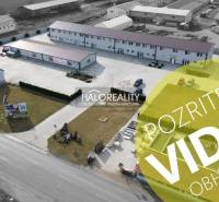 Building with parking lot, commercial spaces, advertising banners, paved areas, drone footage.
