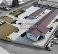 The industrial area includes commercial spaces, a parking lot, and offices surrounded by greenery.