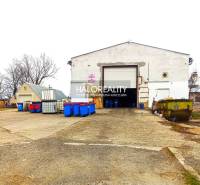 An industrial building with a dilapidated appearance and various colored containers in the office area.